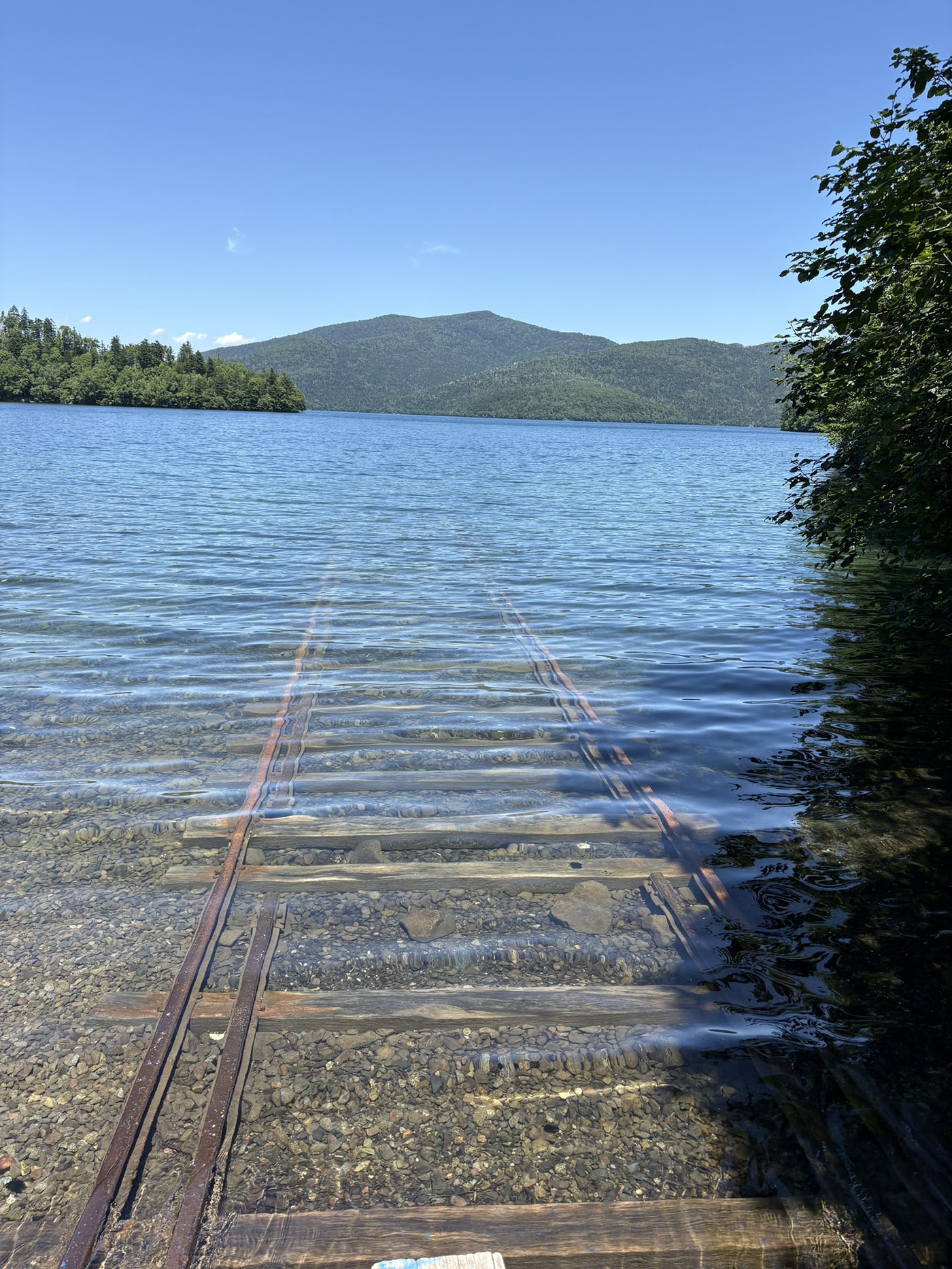 晴天の下、然別湖に続く湖底線路が透き通る水に映える