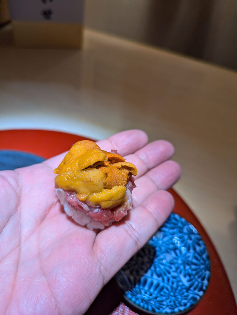 札幌・弐ノ蔵の創作寿司より。職人の手から受け取ったウニの握り