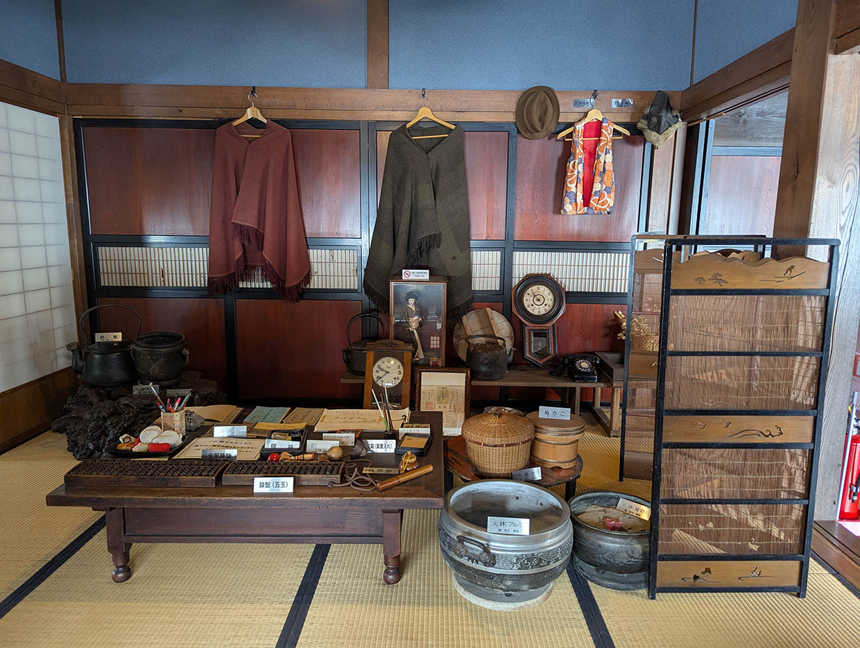 開拓記念館の和室に並べられた生活道具や衣類の展示