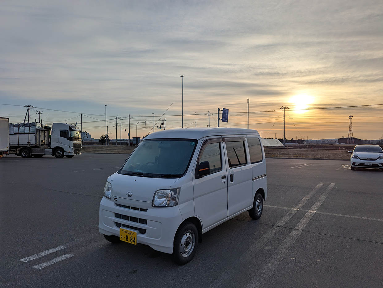 道の駅士幌の駐車場に停めた白い軽バンと朝日