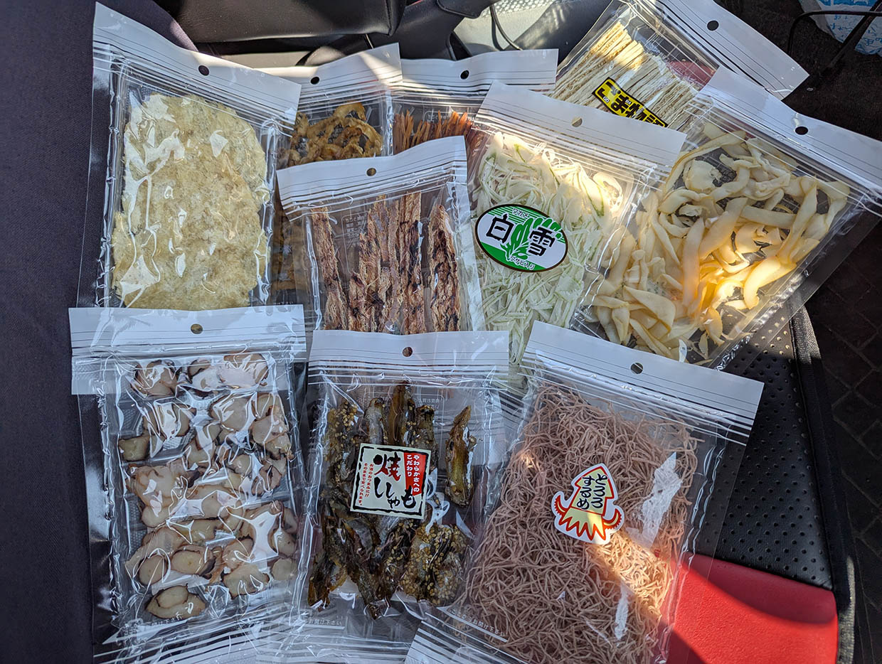 車のシートに並べられた、干物や珍味などのつまみ各種