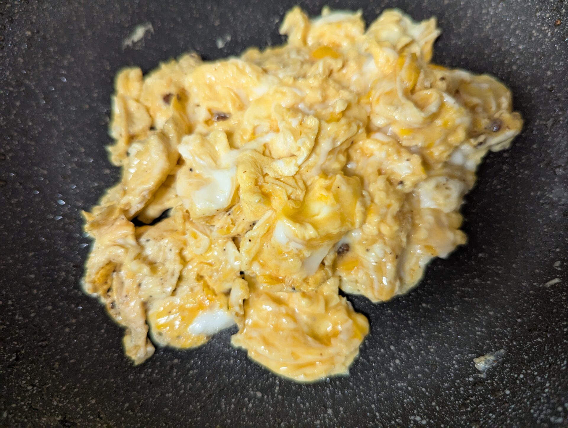 フライパンの上でとろとろに炒められた卵。ほどよい火の入り具合が美味しそう。