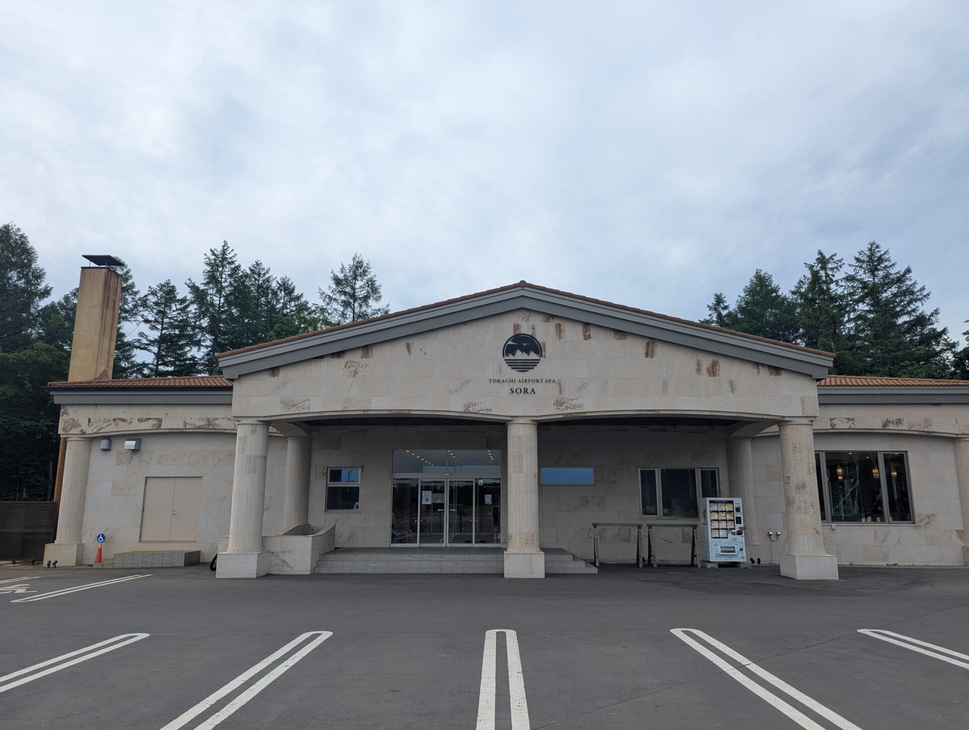 十勝帯広空港近くにある温浴施設『十勝エアポートスパ SORA』の落ち着いた雰囲気の外観。広い駐車場とシンボルマークのあるファサードが特徴。