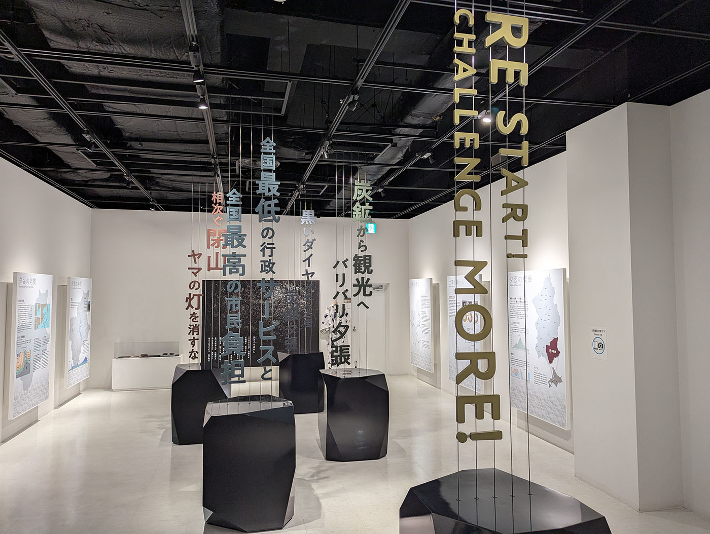 夕張石炭博物館の展示室に吊るされた「RESTART! CHALLENGE MORE!」の文字と夕張の現状を表す言葉