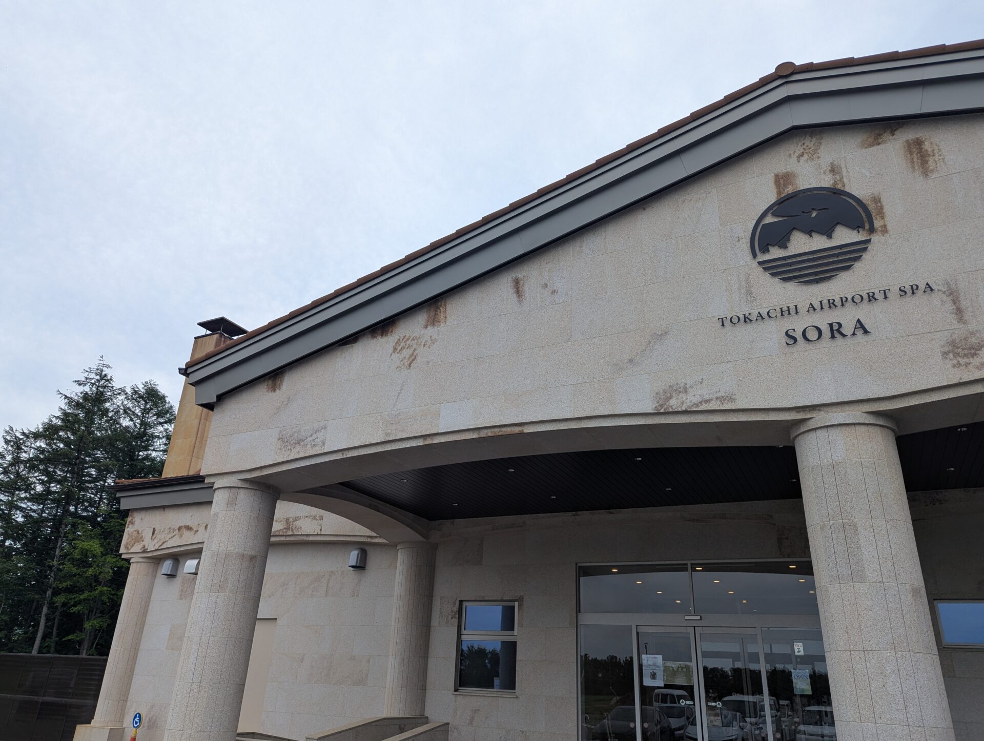 十勝エアポートスパそらの外観、入口とロゴが見える石造りの建物