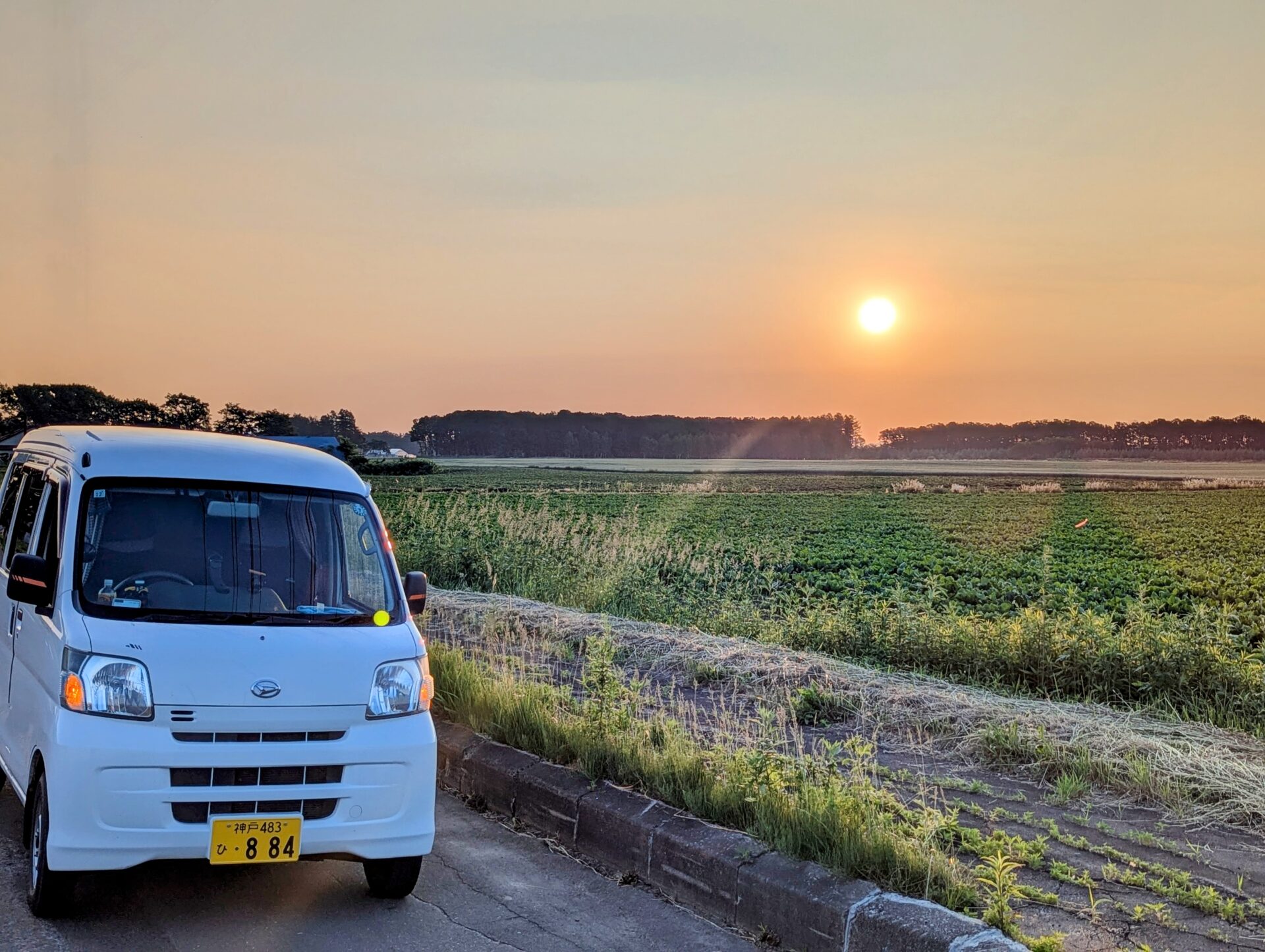 鹿追から一本木展望タワーに向かう途中、畑と白い軽バン越しに昇る朝日
