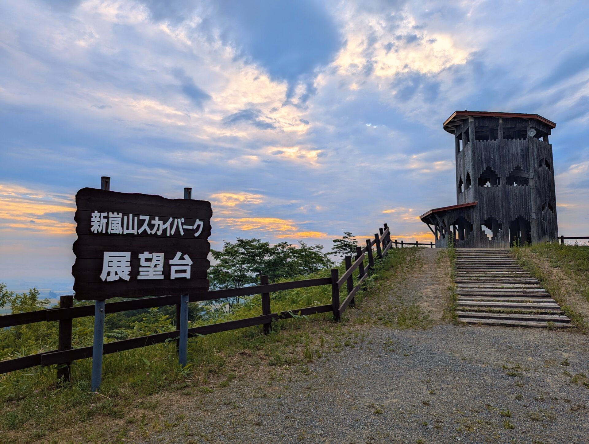 新嵐山スカイパーク展望台の看板と木造の展望塔、階段を上った先に広がる空