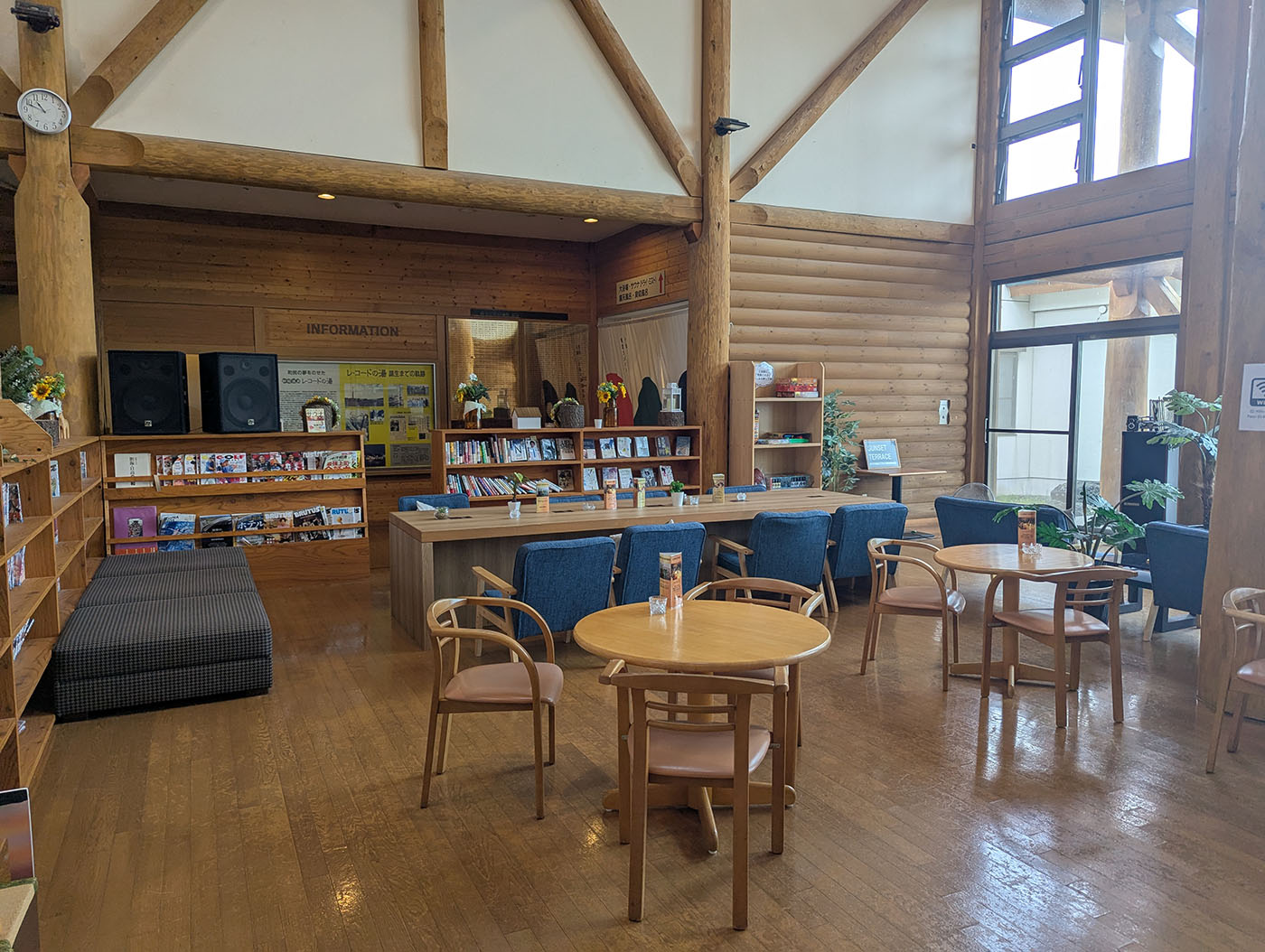 木の温もりを感じる新冠温泉の休憩スペース。テーブルや椅子が整い、書籍やレコードが並ぶ。