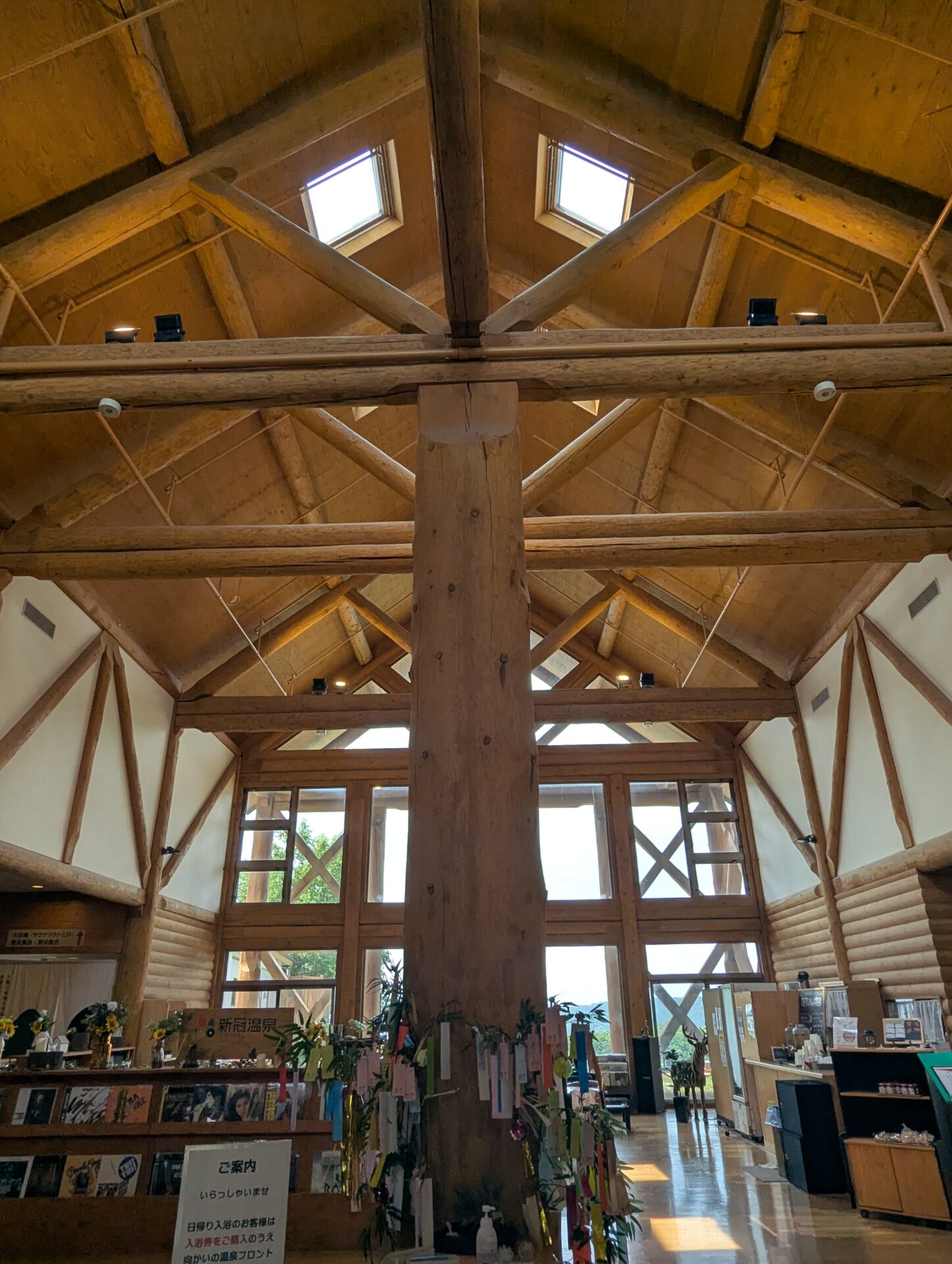 新冠温泉の館内中央にそびえる大きな木の柱。天井が高く、梁が美しいログハウスの構造が印象的。短冊の飾りも見える。