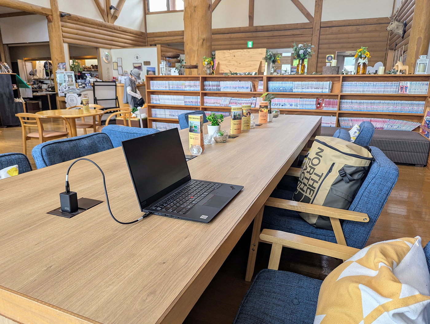 電源に接続されたノートパソコンが置かれた、新冠温泉の木のテーブル席