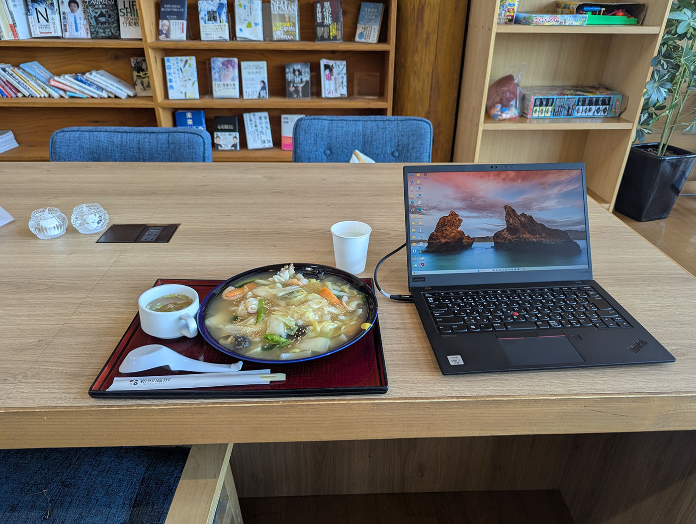 新冠温泉の休憩テーブルで、ノートパソコンと並んだ海鮮飯のランチ