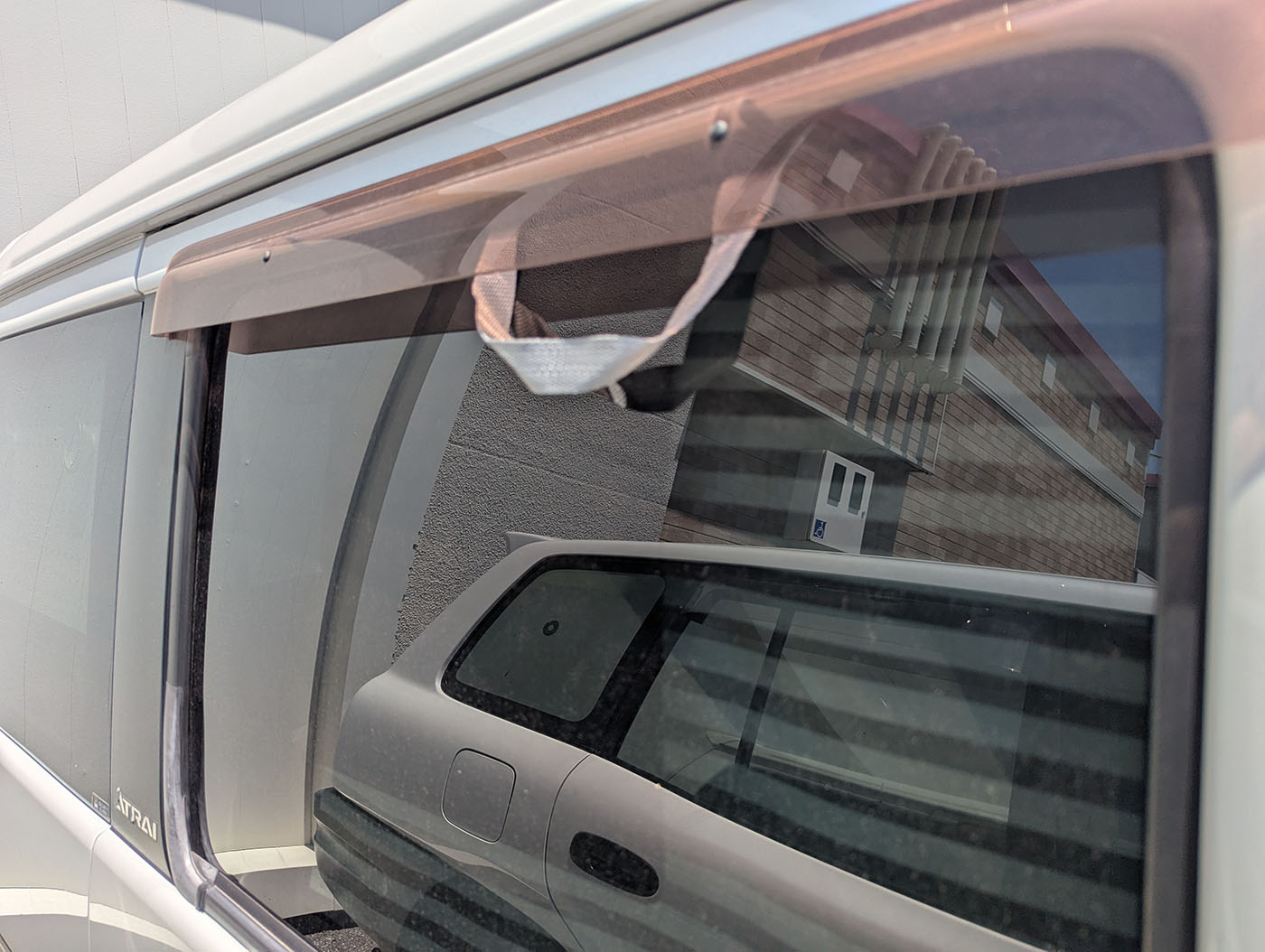 車外から見たランドリーバッグの取っ手がドアバイザーの外に出ている様子