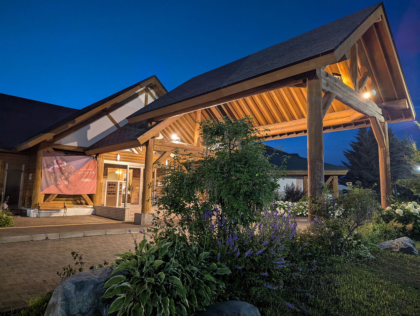 新冠温泉の入口。夜空の下、木造の美しい屋根と温かいライトが迎える