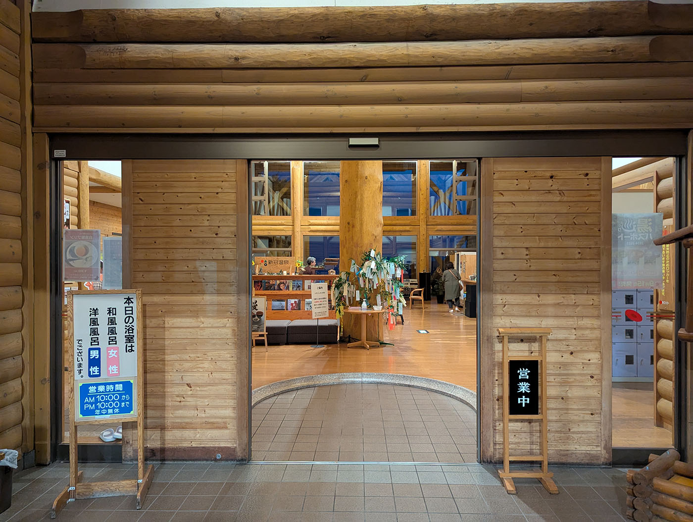 新冠温泉の館内入口。木の壁に囲まれたロビーが見える