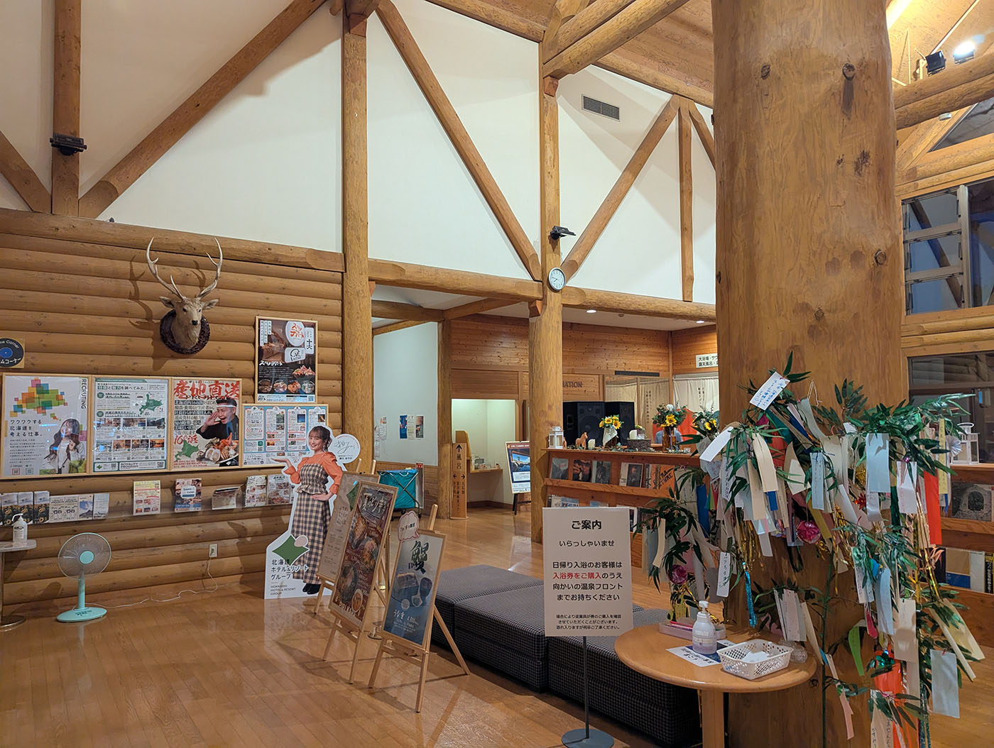 新冠温泉のロビー。鹿の剥製や観光案内、短冊飾りが並ぶ