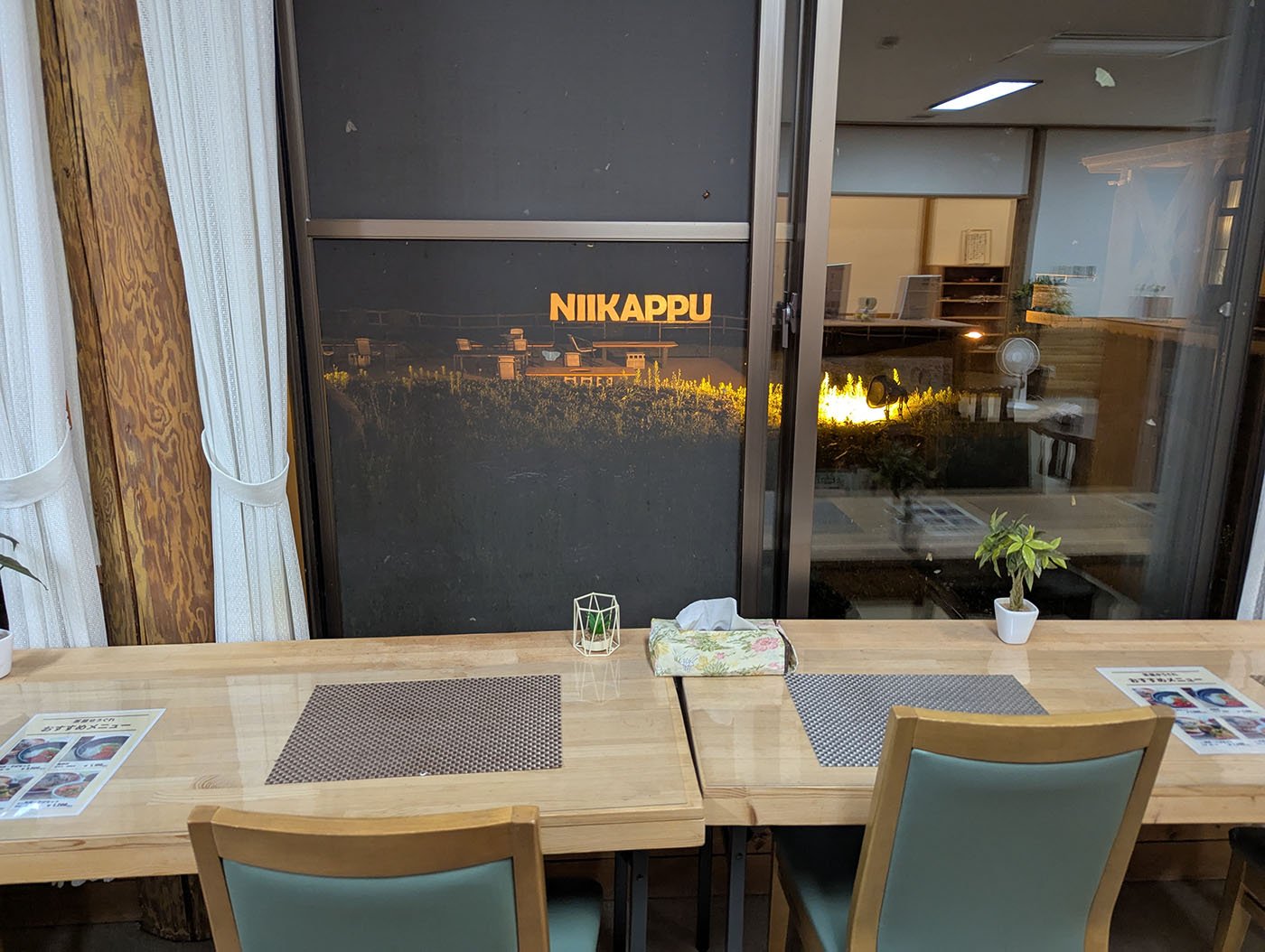 窓際のカウンター席。外にはライトアップされた『NIIKAPPU』の文字が見える