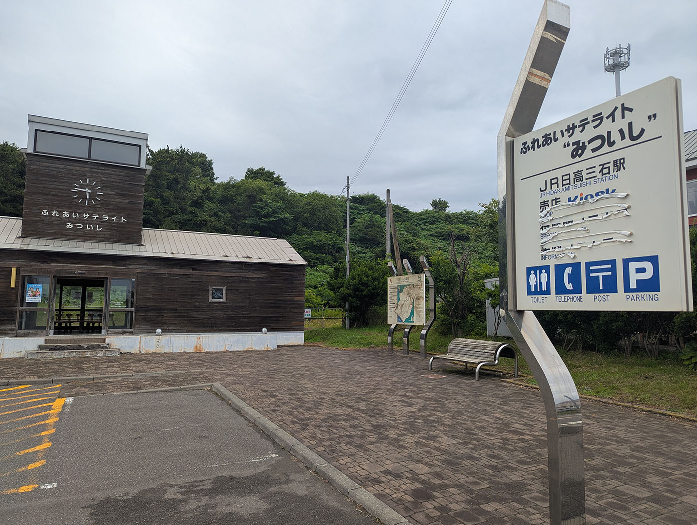 木造の小さな建物「ふれあいサテライトみついし」の外観と駅名看板（旧JR日高三石駅跡）