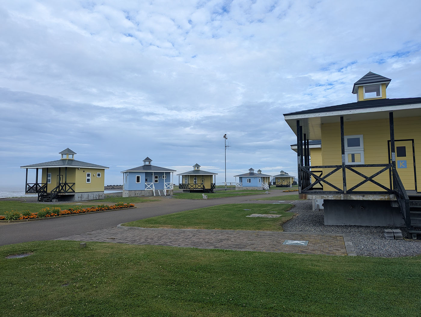 海沿いに並ぶ青と黄色のバンガロー（道の駅みついしオートキャンプ場）