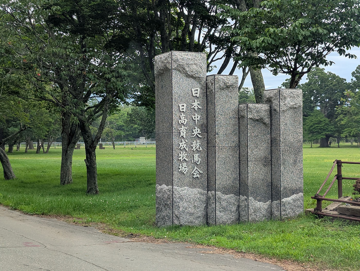 日本中央競馬会（JRA）日高育成牧場の石碑。緑の牧場に囲まれた記念碑。