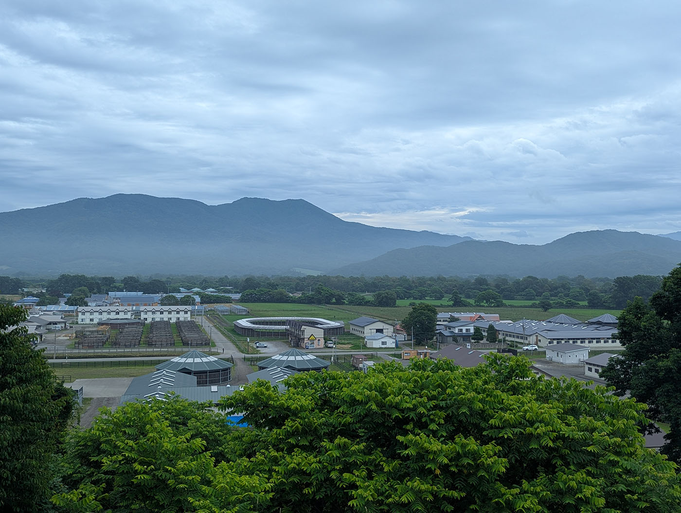 日高育成牧場を一望できる展望台からの景色。山々と牧場施設が広がる絶景。