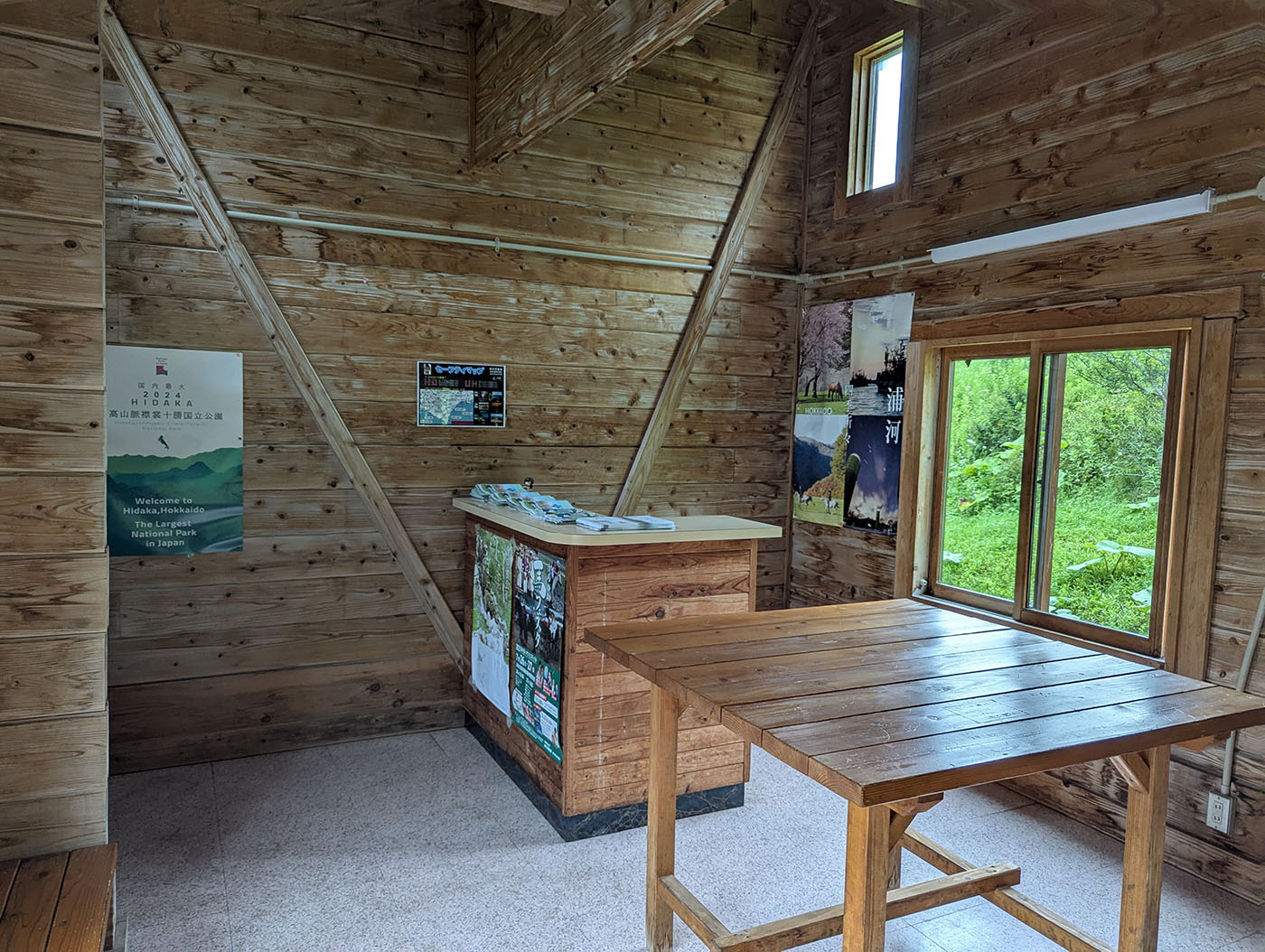 翠明橋公園案内所の木の内装と窓からの緑