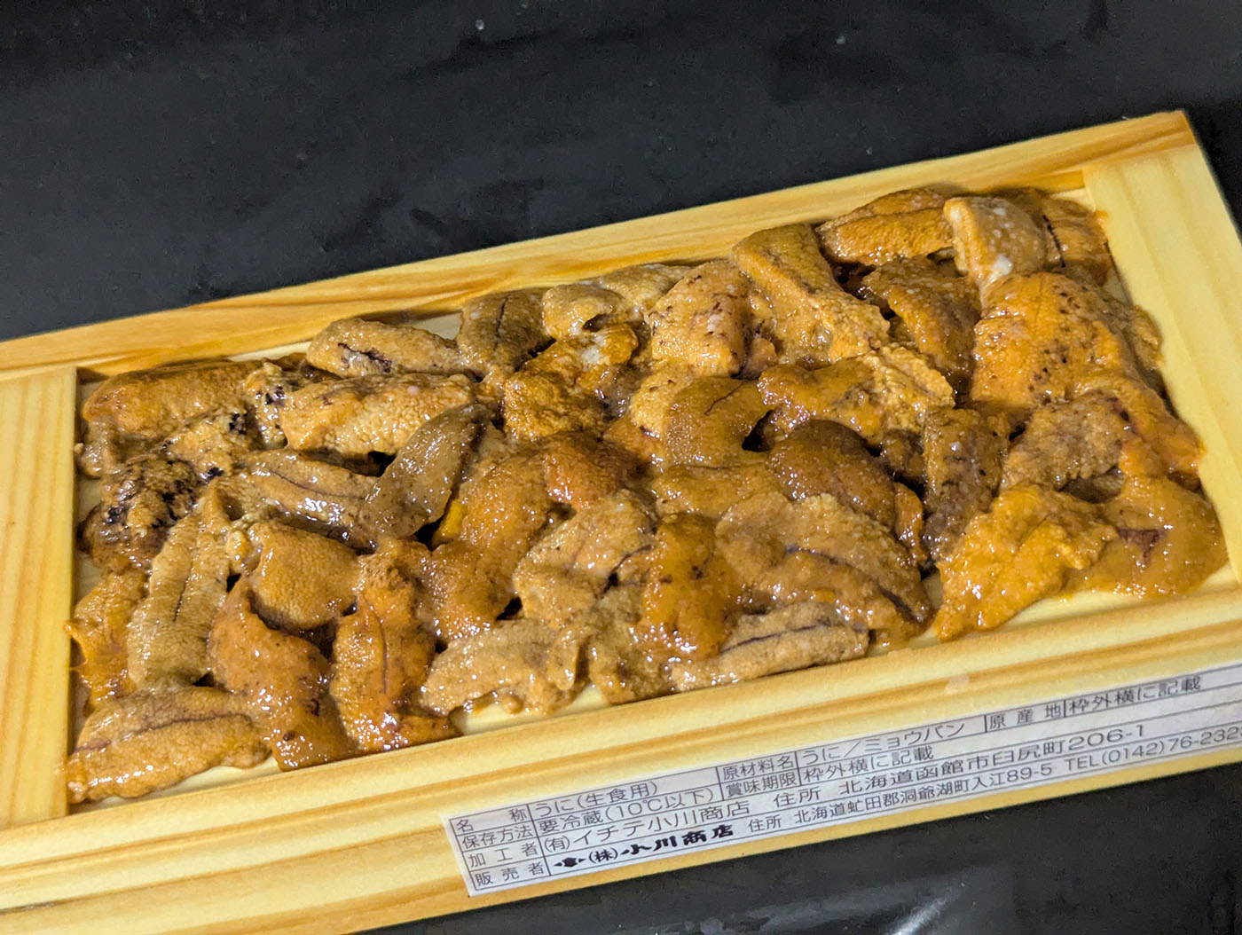 帯広の生鮮市場で購入したロシア産生うに。木箱にぎっしり詰められた鮮やかなオレンジ色のうにが並ぶ。