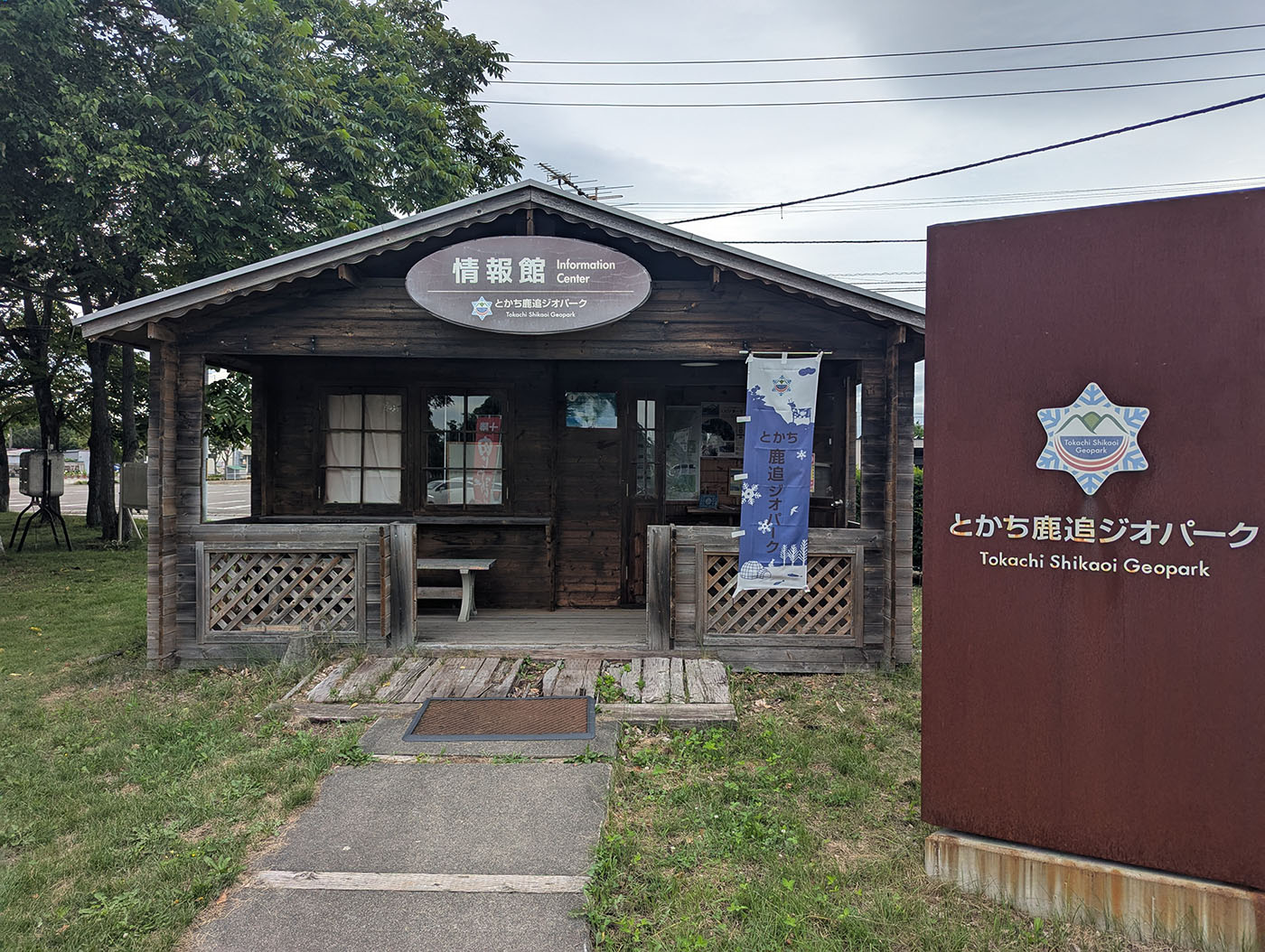 「とかち鹿追ジオパーク」の情報館。ログハウス風の建物の隣には大きな案内サインが設置されている。