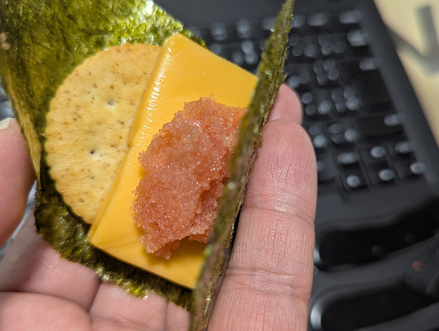 タラコ、スライスチーズ、クラッカーを海苔で巻いた即席おつまみ。手で持って食べるスタイル。