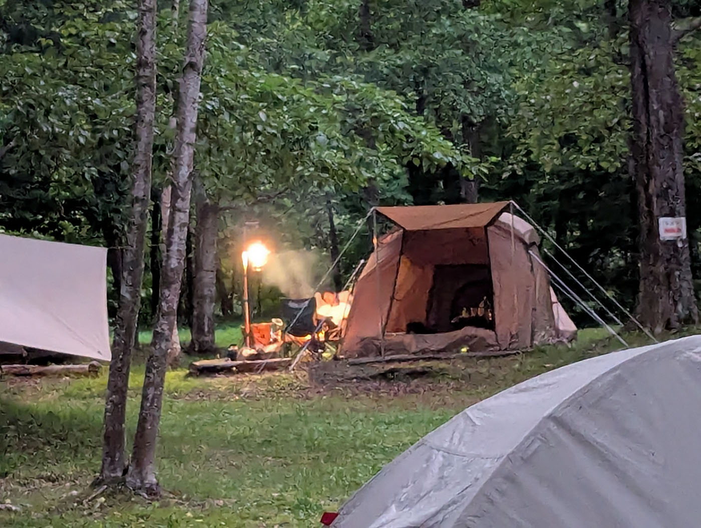 糠平野営キャンプ場で焚き火の炎に照らされたテントサイトの夜景