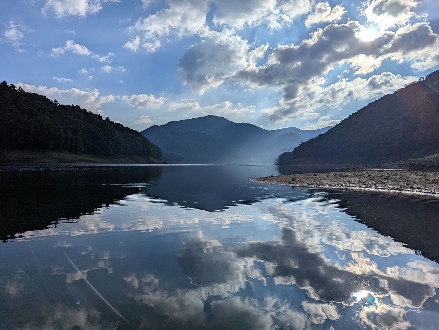 糠平湖に映り込む雲と山々の幻想的な風景