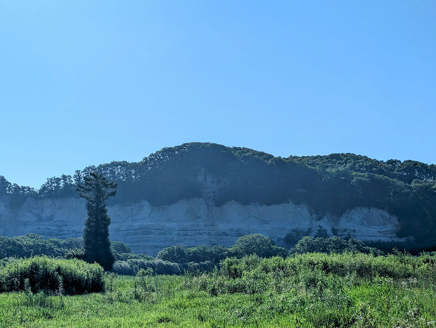 上愛冠の白い断崖とその前に広がる緑の草地、青空に映える風景
