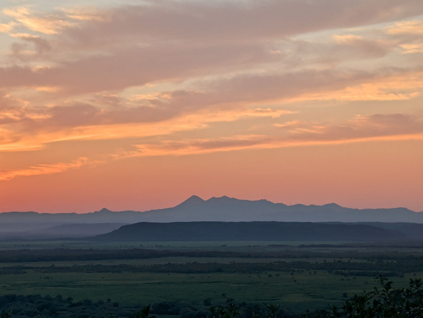 細岡展望台から望む阿寒岳のシルエット。夕暮れの空がグラデーションに染まり、湿原に静けさが広がる情景。