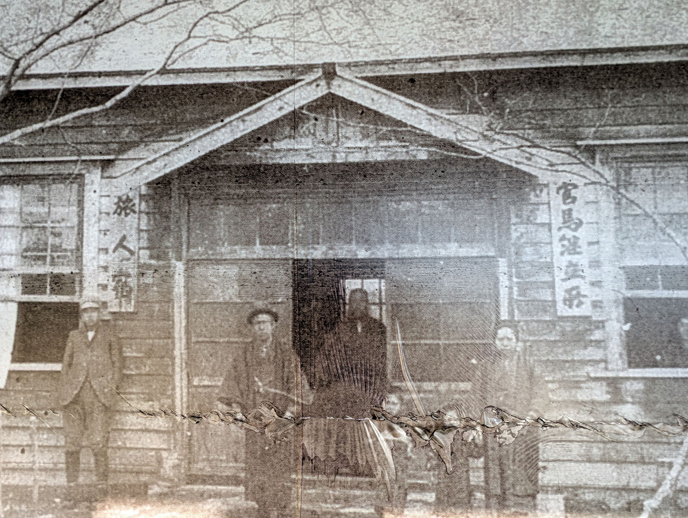 大正2年に撮影されたクテクウシ駅逓の写真。木造の建物前に数名の男性が立ち並ぶ。