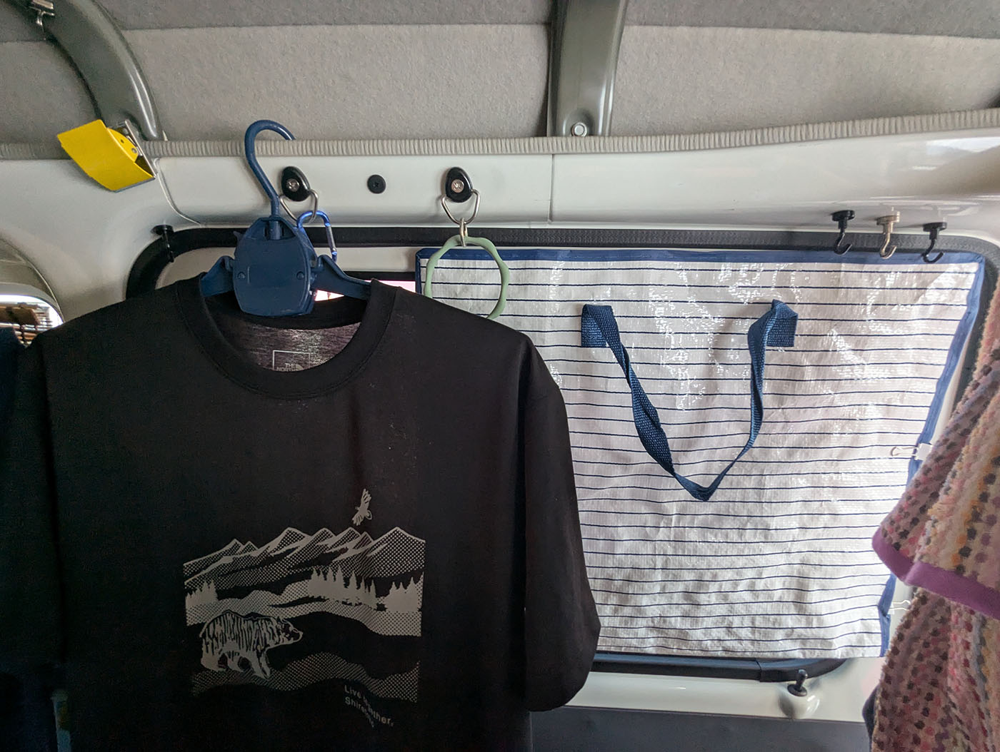 軽バン車内でTシャツを干しつつ、マグネットと手作りプラバンで窓に遮光シートを固定した自作の夏用遮光対策