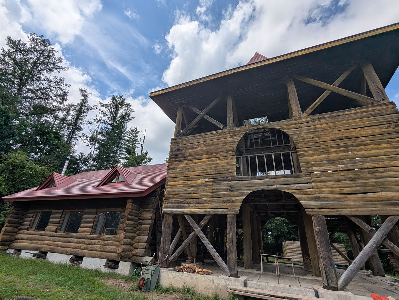 ログハウス風の木造校舎と赤い屋根、青空の下に建つ植村直己・帯広野外学校の建物。