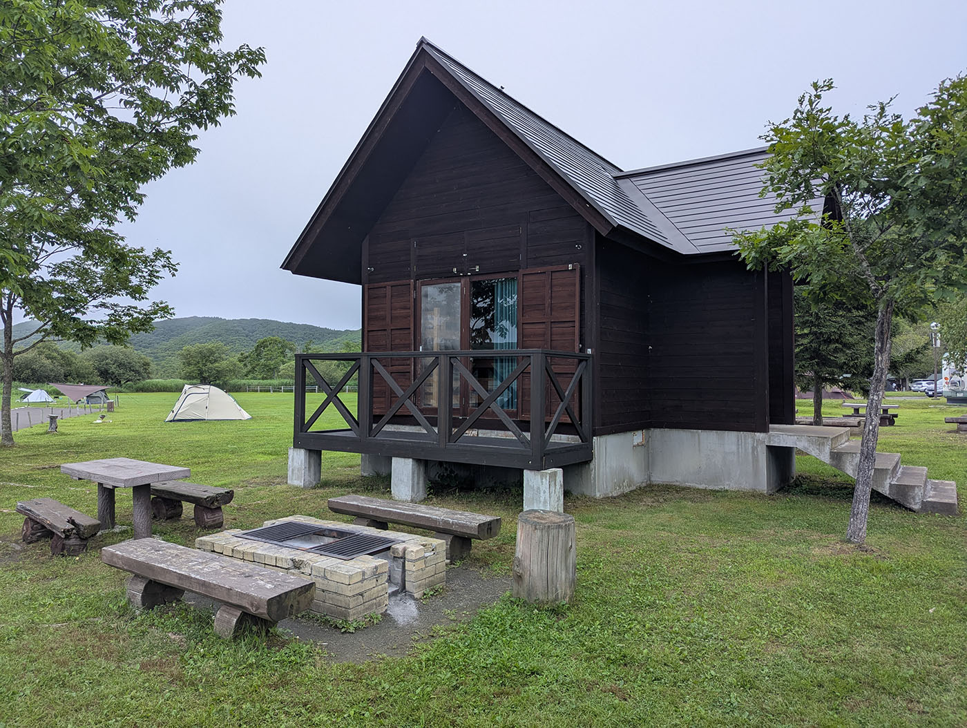 達古武キャンプ場のロッジ外観、バーベキュー炉とテーブル付き