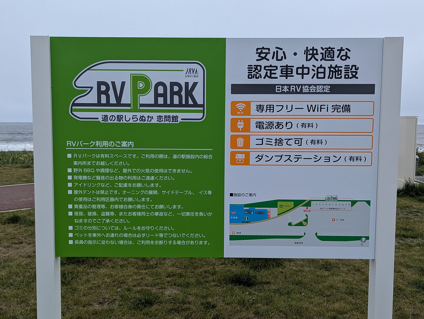 RVパークの案内板と海辺の風景