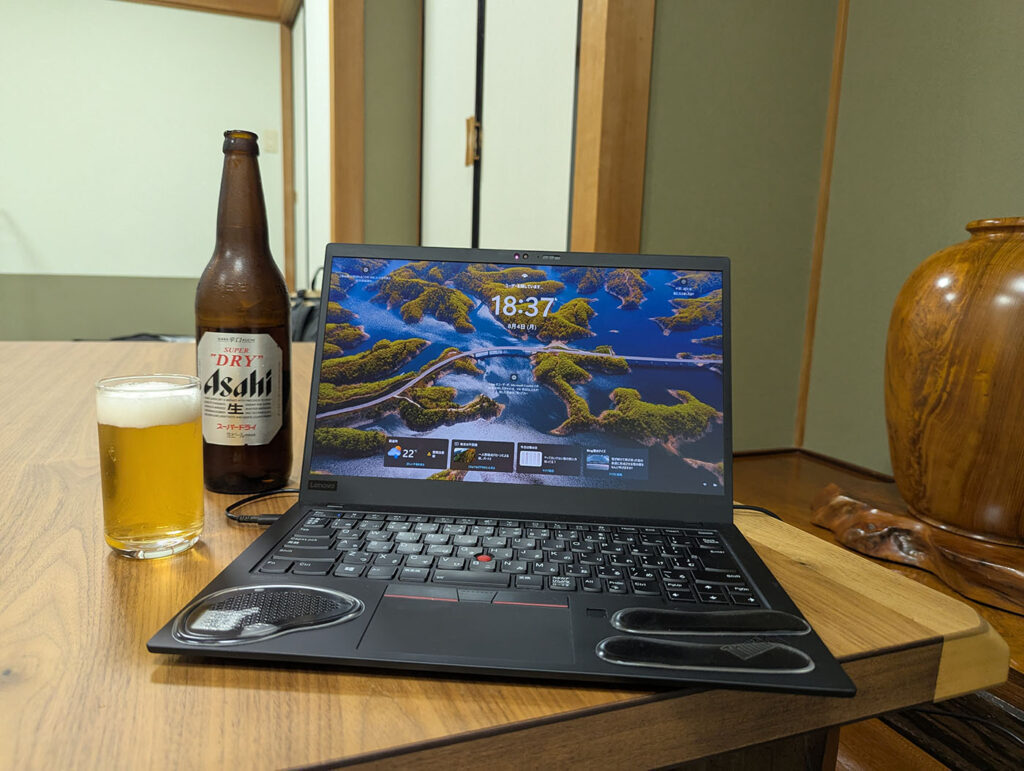 旅館の和室にノートPCと瓶ビールを置き、車中泊旅の合間に畳の部屋でくつろぎながら作業する様子