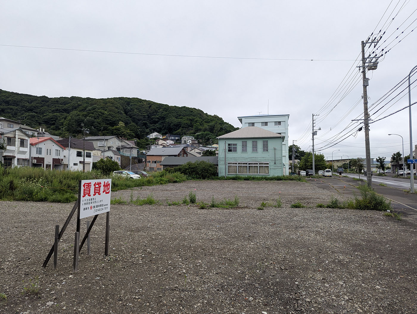 貸地看板と旧三菱合資会社室蘭出張所を同じフレームに収めた写真
