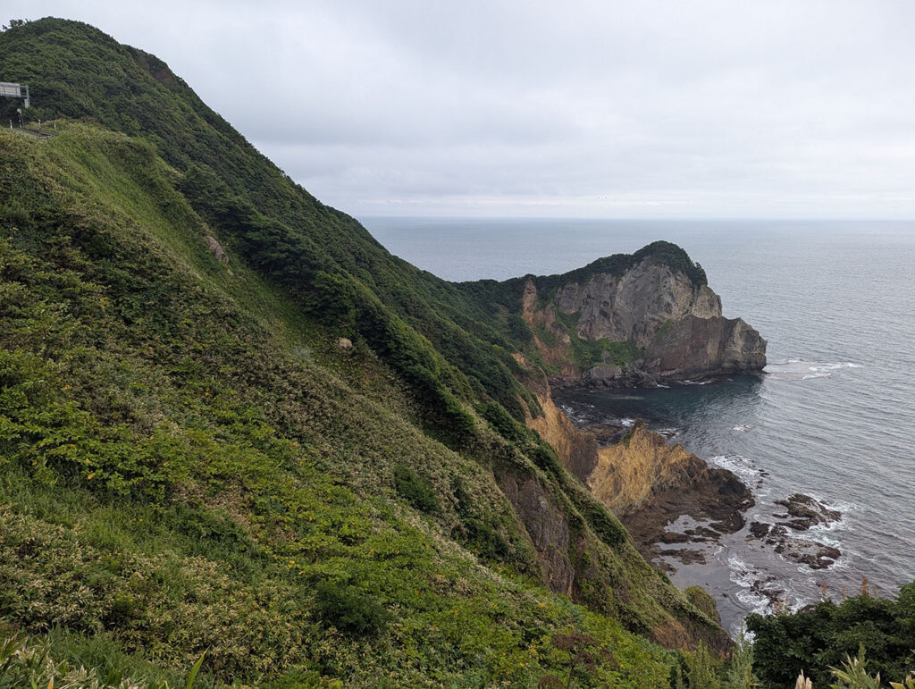 海と山並みを背景にした金屏風の全景