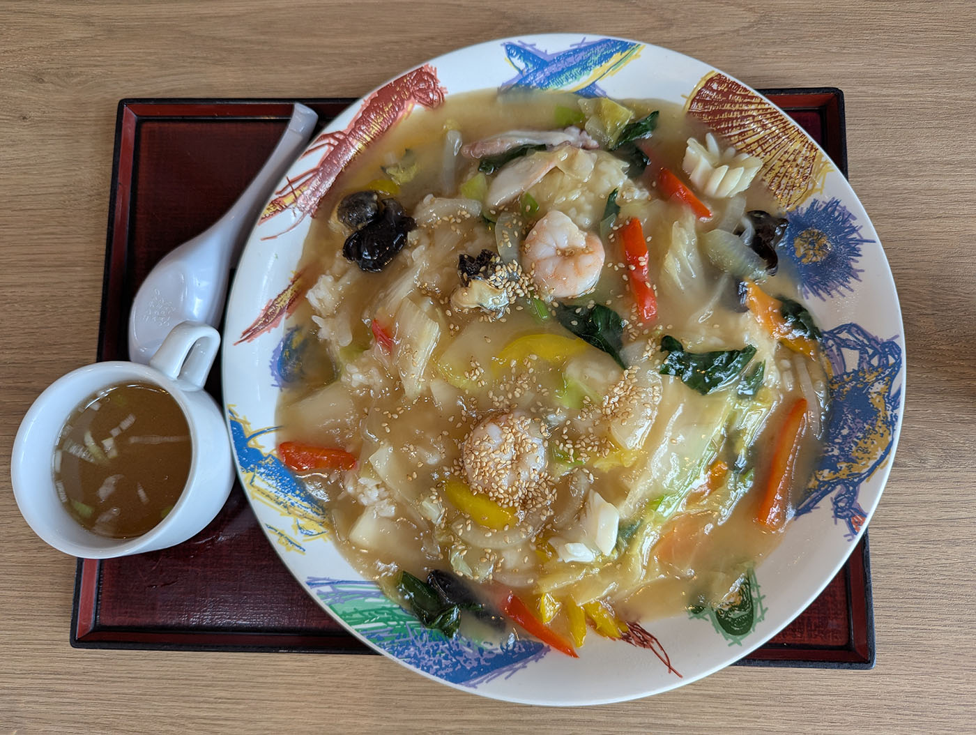 新冠温泉で注文した海鮮あんかけご飯。エビやイカ、野菜が彩り豊かに盛られている。