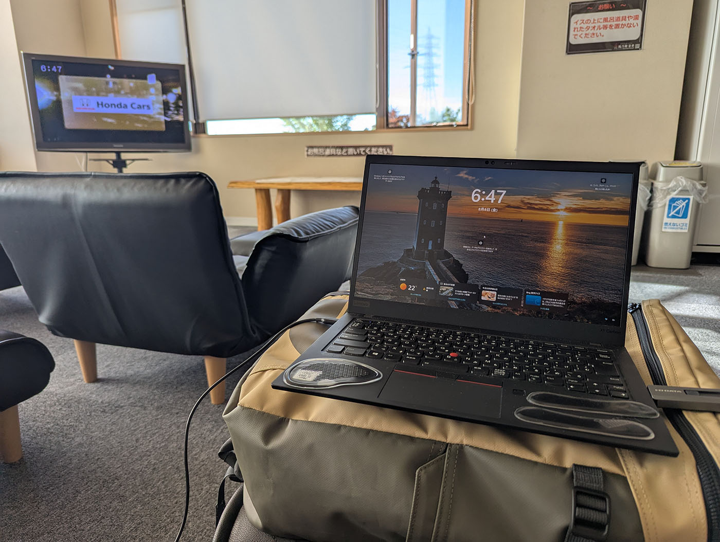 温泉施設の休憩室でノートPCを開いて仕事をする様子