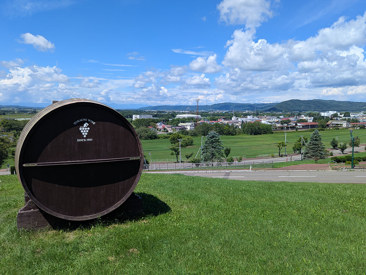 青空の下にそびえる池田ワイン城と入口前の巨大ワイン樽