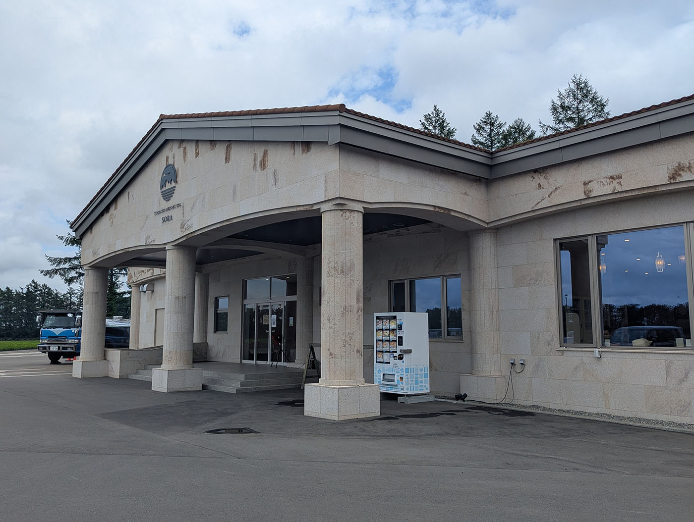 十勝エアポートスパそらの外観。石造りの建物が堂々と立ち、入口横には自販機が設置されている。