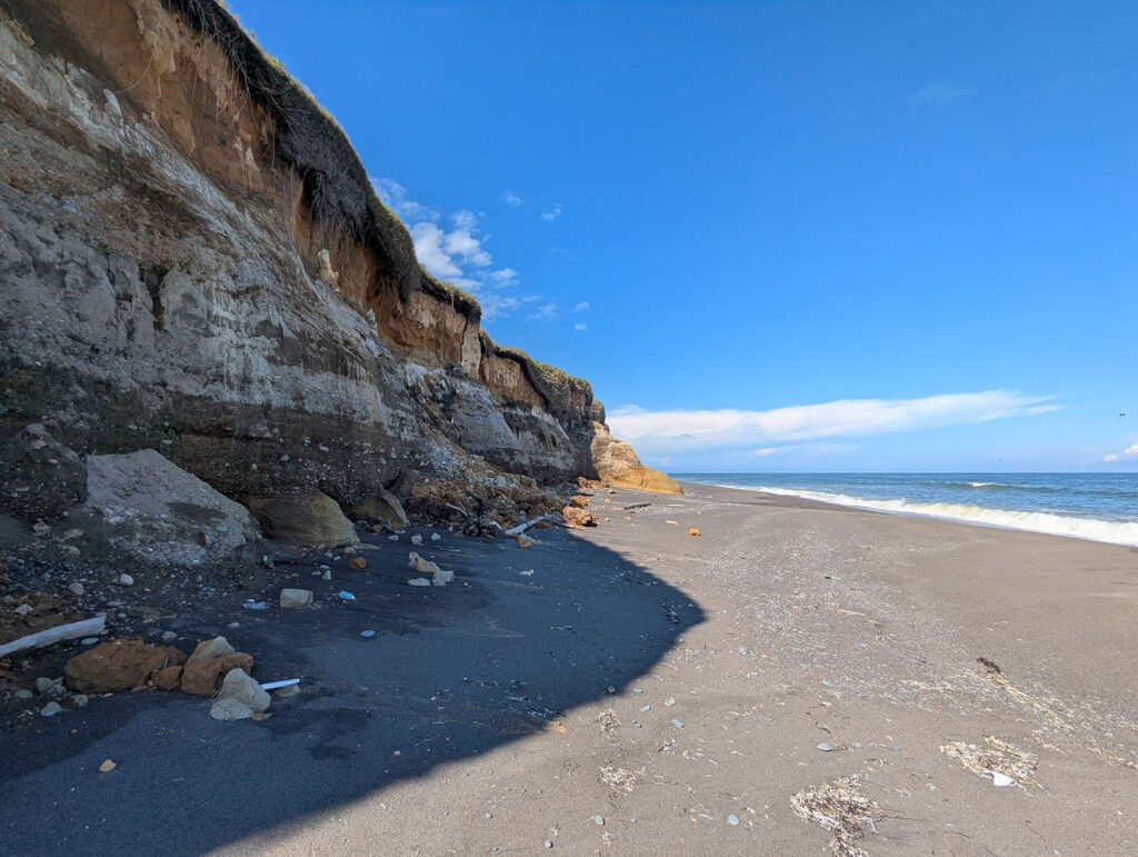 晩成海岸にそびえる断崖。地層がくっきりと見える荒々しい岩肌と、青い空と太平洋が広がる景観。