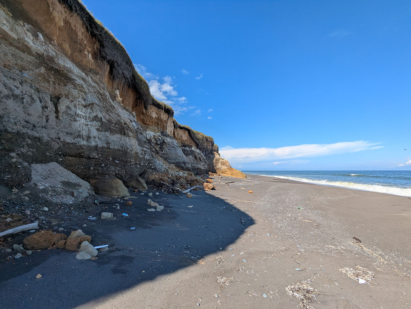 晩成海岸にそびえる断崖。地層がくっきりと見える荒々しい岩肌と、青い空と太平洋が広がる景観。