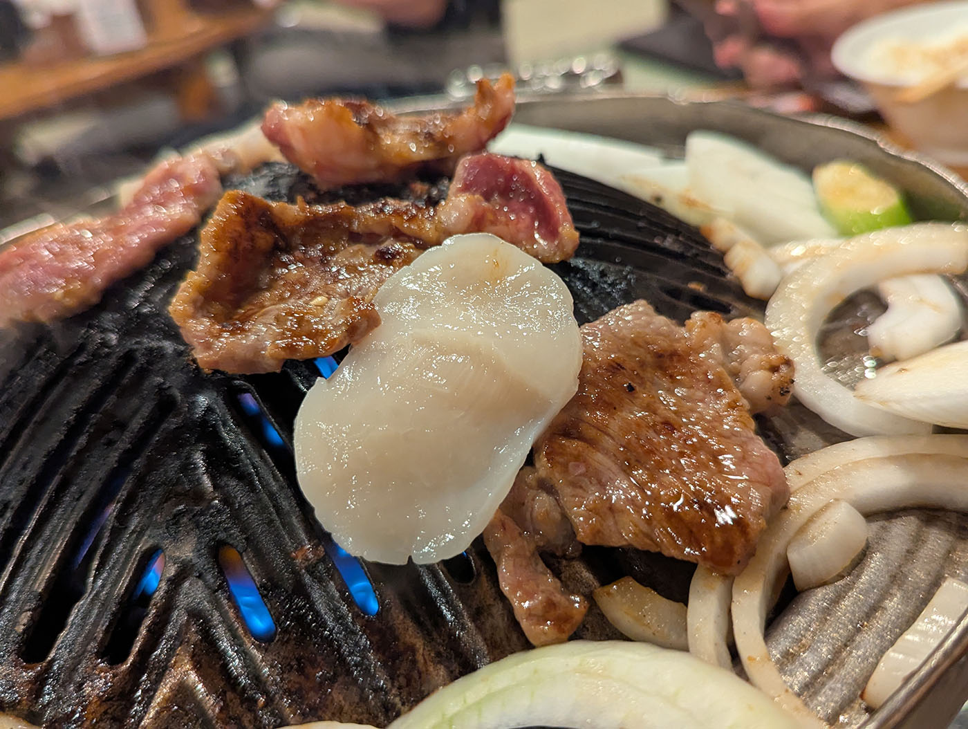 帯広の人気店「じんぎすかん北海道」で焼かれるラム肉とマトン。鉄板の上で玉ねぎと一緒に香ばしく焼き上がっている。
