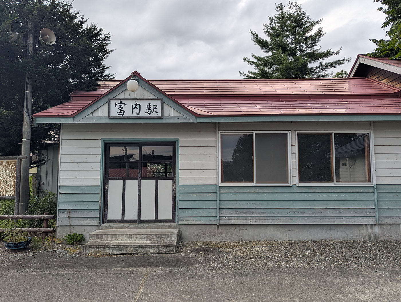 北海道むかわ町の旧富内駅駅舎。赤い屋根と水色の外壁が特徴的で、正面には「富内駅」の駅名看板が掲げられている。