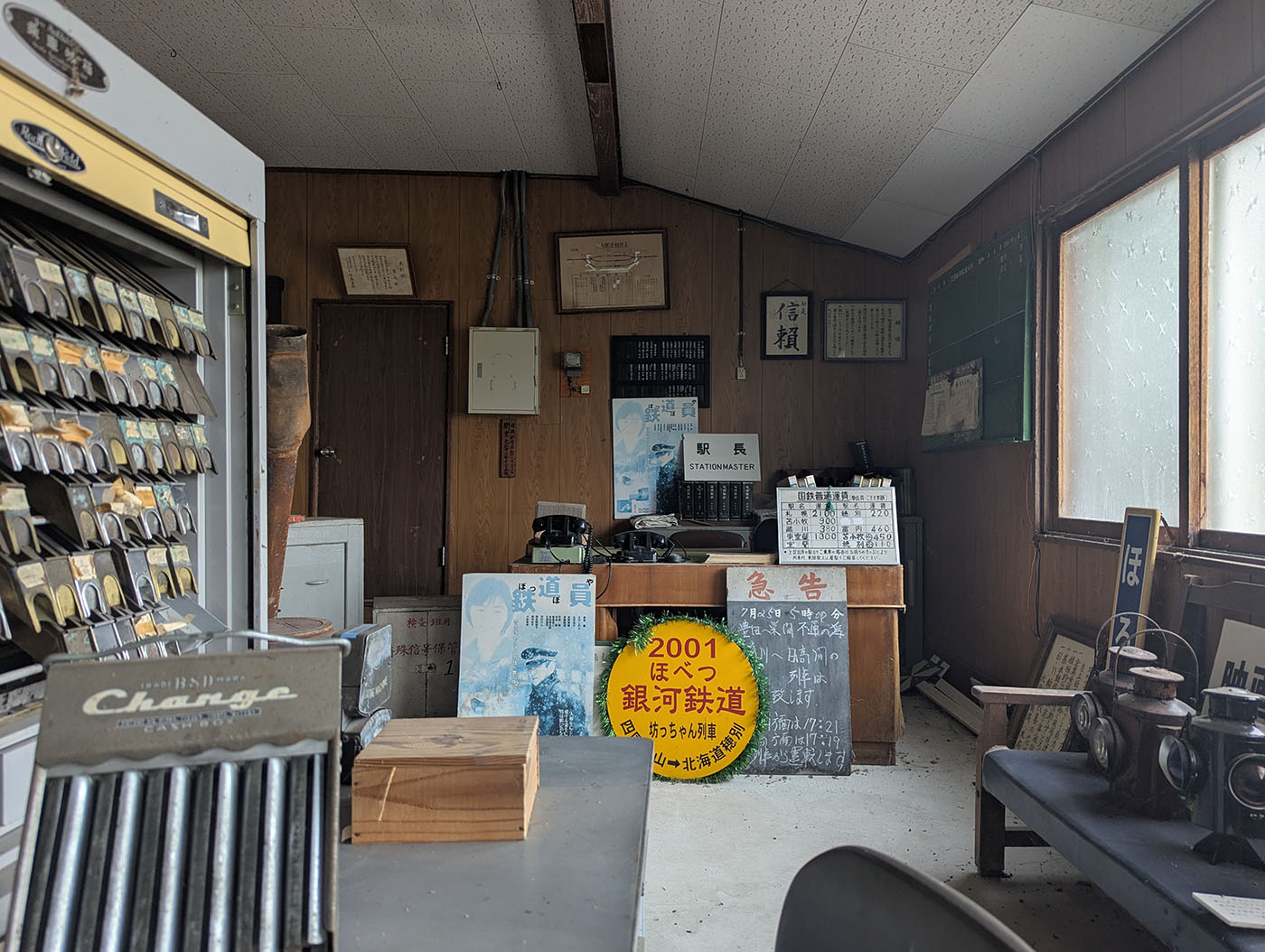 富内駅舎内の旧駅長室。木製カウンターや運賃表、鉄道ランプ、古い看板や掲示物が残され、昭和時代の雰囲気を漂わせている。