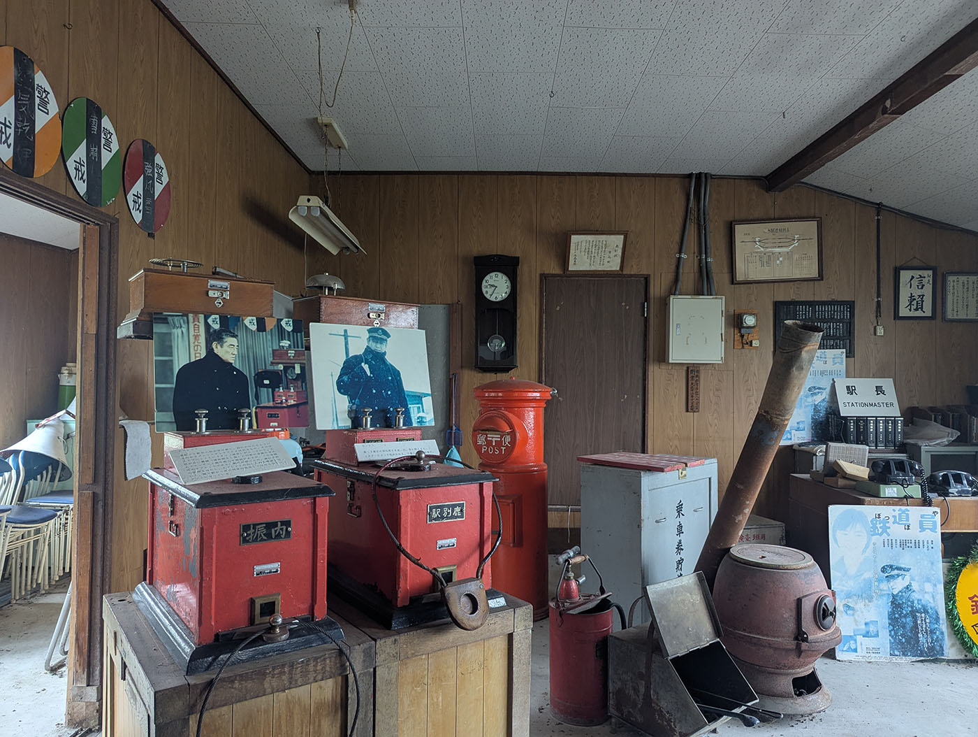 北海道むかわ町の旧富内駅の駅舎内展示。赤いポストやストーブ、駅名標、信号てこなど、廃線当時の鉄道備品や写真が並ぶ。